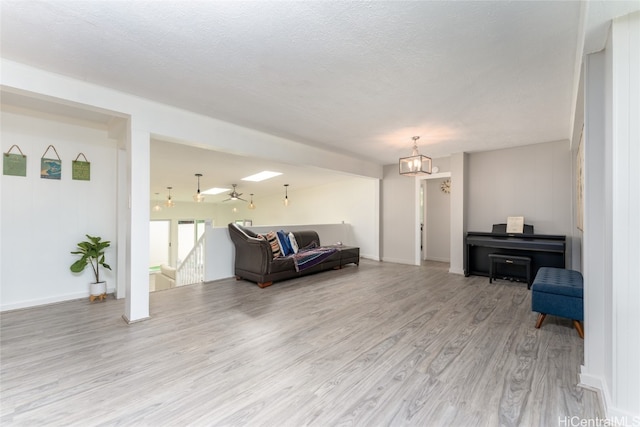 living room with a textured ceiling and light wood-type flooring