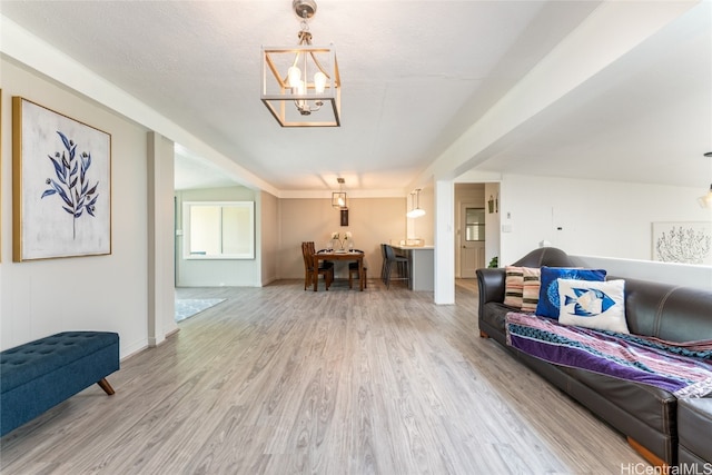 living room featuring hardwood / wood-style flooring, a textured ceiling, and a chandelier