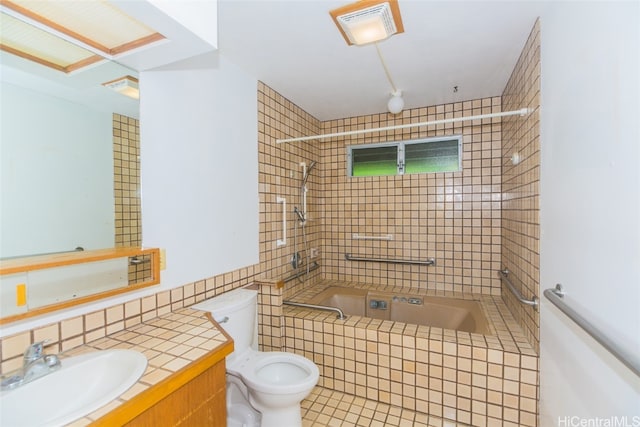 full bathroom featuring tiled shower / bath, tile walls, toilet, vanity, and tile patterned floors