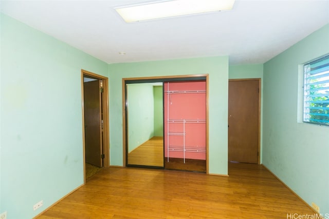 unfurnished bedroom with a closet and light wood-type flooring