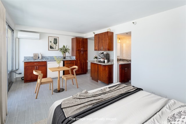 bedroom featuring ensuite bath and an AC wall unit