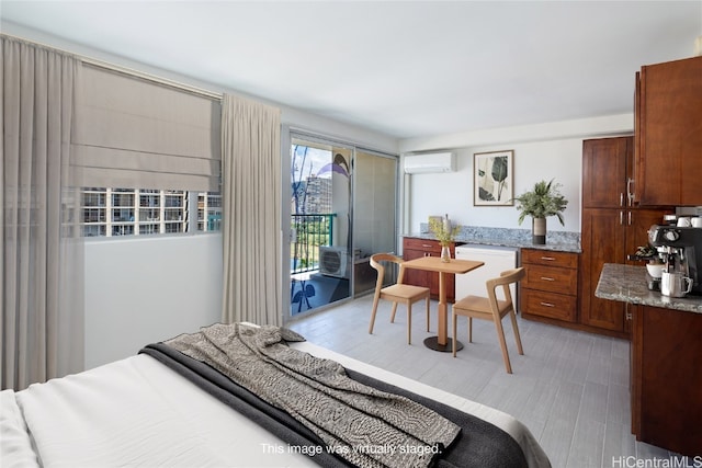 bedroom featuring an AC wall unit, access to outside, and light hardwood / wood-style flooring