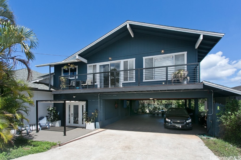 view of front of property featuring french doors, a carport, and a balcony