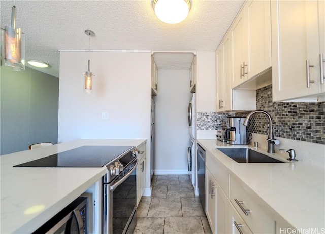 kitchen featuring appliances with stainless steel finishes, backsplash, hanging light fixtures, a textured ceiling, and sink