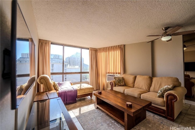 living room with ceiling fan, a textured ceiling, and floor to ceiling windows