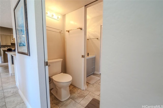 bathroom featuring toilet, tile patterned flooring, and backsplash