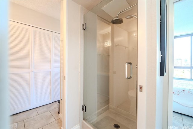 bathroom featuring a textured ceiling, tile patterned floors, and walk in shower