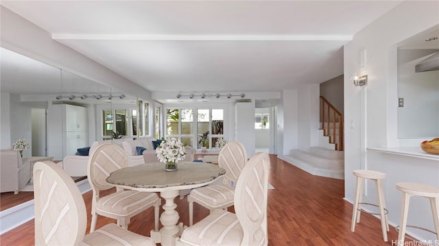 dining room with rail lighting and hardwood / wood-style floors