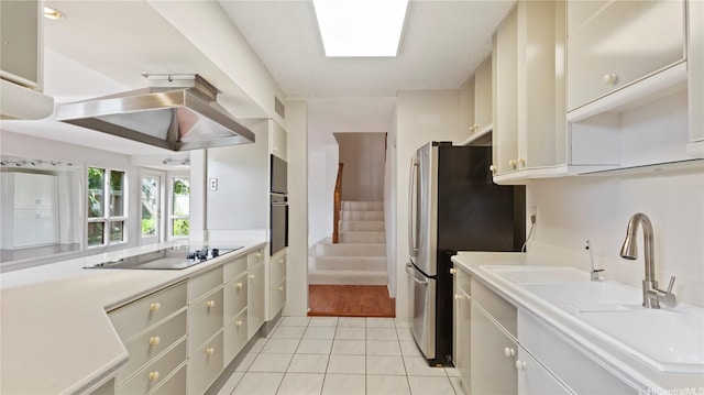 kitchen featuring visible vents, light countertops, a sink, light tile patterned floors, and black appliances