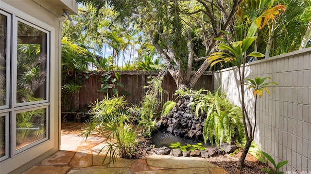 view of yard featuring a fenced backyard and a garden pond
