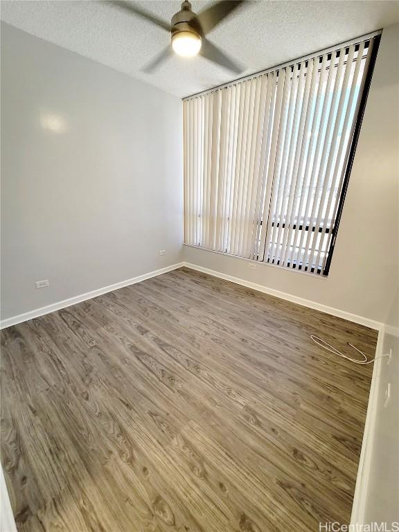 unfurnished room with hardwood / wood-style flooring, ceiling fan, and a textured ceiling