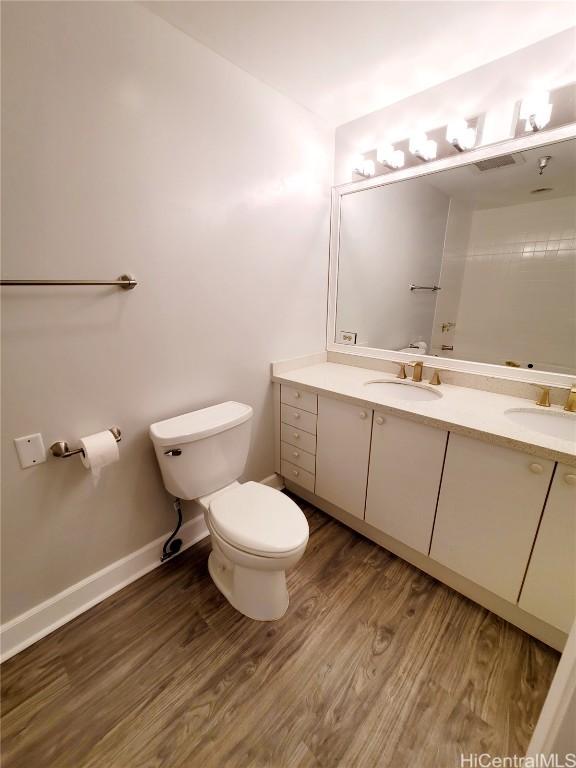 bathroom with hardwood / wood-style flooring, vanity, and toilet