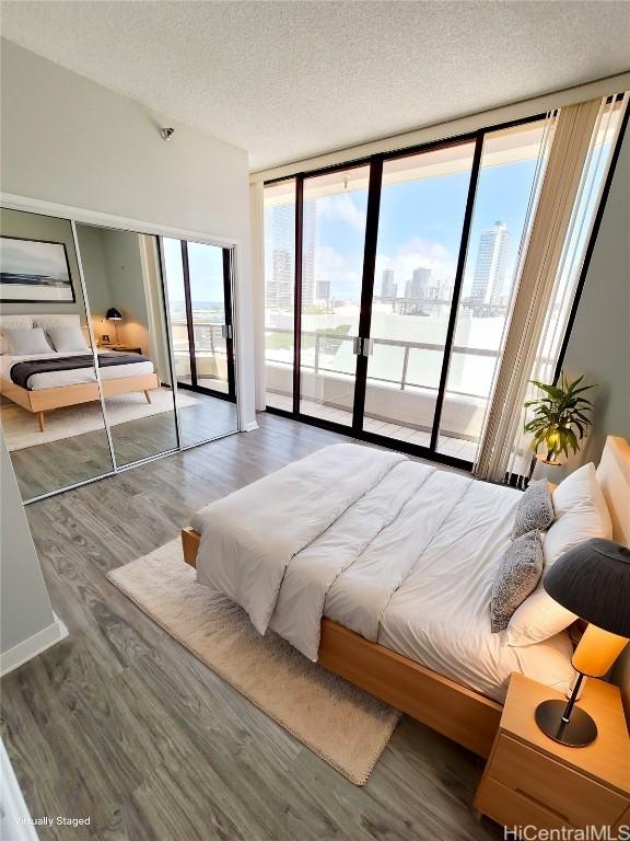 bedroom featuring hardwood / wood-style floors, access to outside, and a textured ceiling