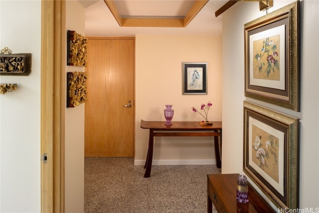 corridor featuring carpet flooring and a raised ceiling