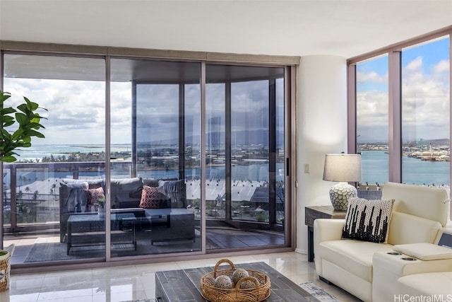 tiled living room with a water view and floor to ceiling windows