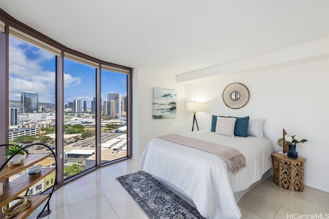 bedroom with a wall of windows, access to outside, and light tile patterned floors