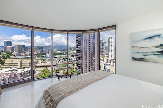 bedroom featuring multiple windows, tile patterned floors, and floor to ceiling windows