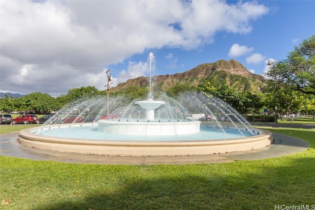 surrounding community with a mountain view and a lawn