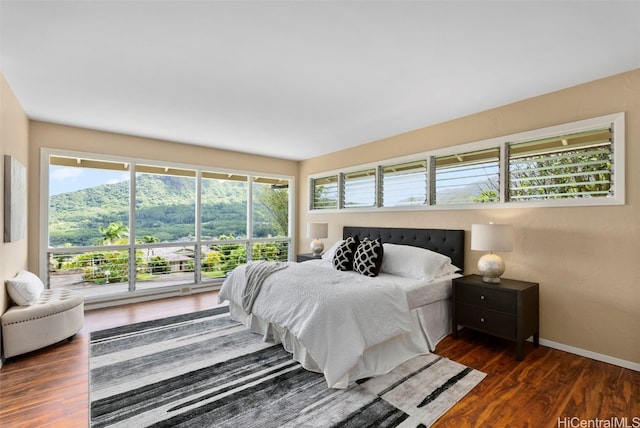 bedroom featuring multiple windows and dark hardwood / wood-style floors