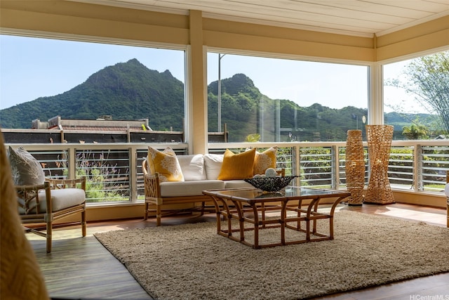 sunroom with crown molding, wood finished floors, and a mountain view
