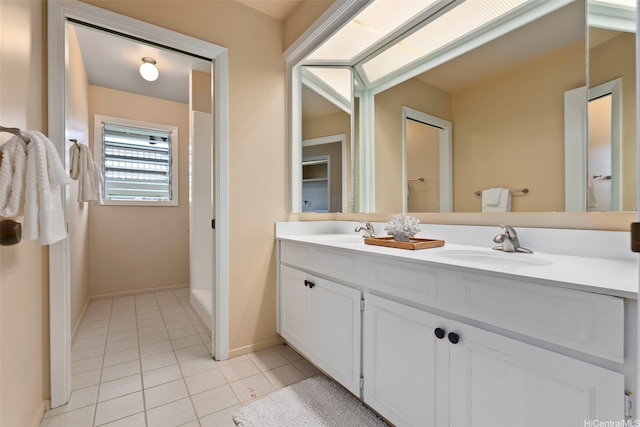full bathroom featuring tile patterned flooring, baseboards, a sink, and double vanity