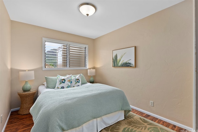 bedroom with wood finished floors and baseboards