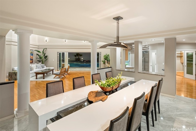 dining room with light hardwood / wood-style floors and decorative columns