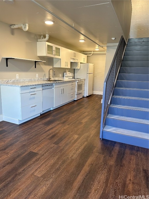 kitchen with dark hardwood / wood-style floors, sink, white cabinetry, light stone counters, and white appliances