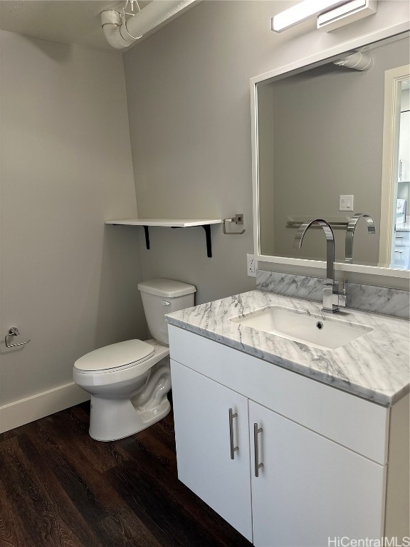 bathroom featuring vanity, hardwood / wood-style flooring, and toilet