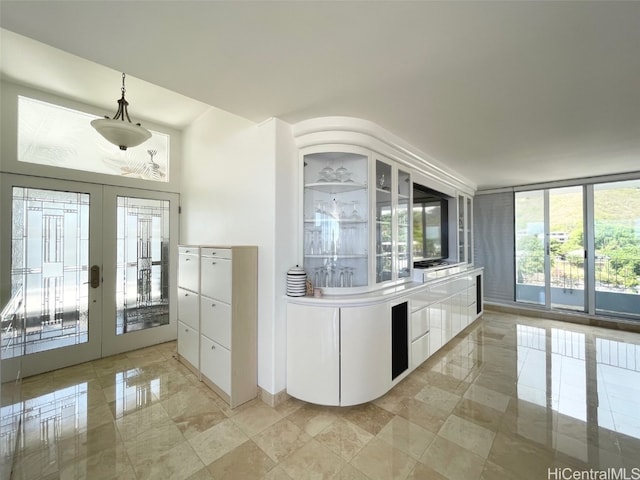 kitchen with french doors, hanging light fixtures, and white cabinets