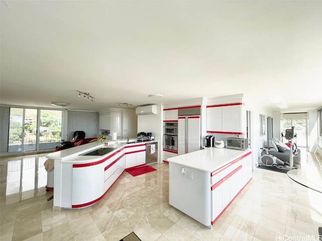 kitchen featuring a kitchen island, white cabinets, a wall mounted air conditioner, and stainless steel appliances