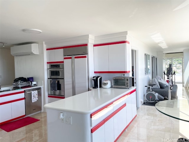 kitchen with appliances with stainless steel finishes, a wall unit AC, and white cabinets