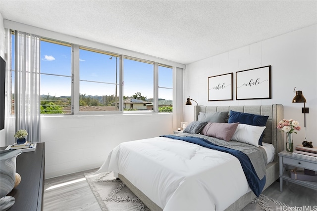 bedroom featuring hardwood / wood-style floors and a textured ceiling