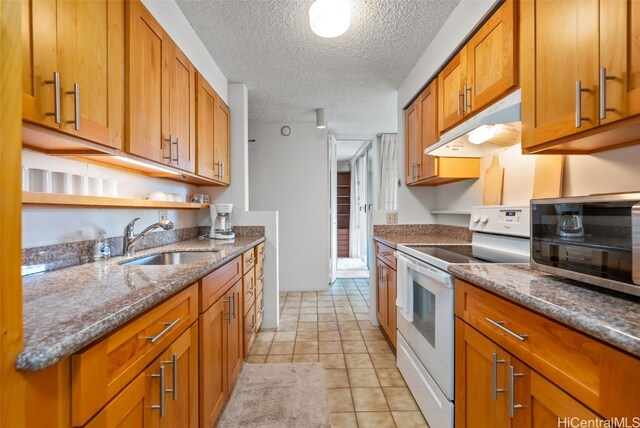 kitchen featuring dark stone counters, sink, light tile patterned flooring, a textured ceiling, and electric stove