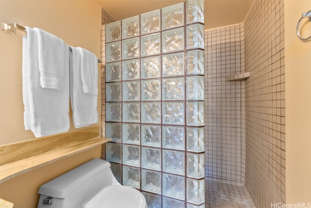 bathroom with toilet and tiled shower