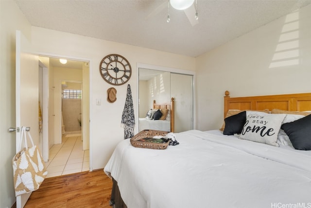 bedroom featuring hardwood / wood-style floors, ceiling fan, a textured ceiling, and a closet