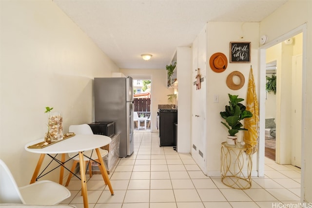 kitchen featuring stainless steel fridge and light tile patterned floors