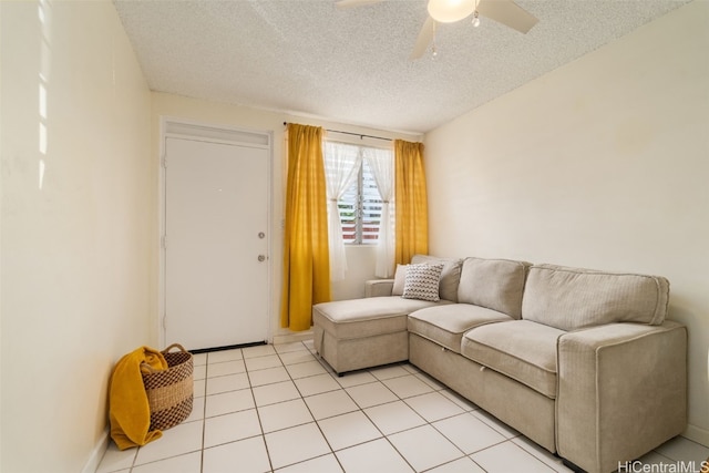 living room featuring ceiling fan, light tile patterned floors, and a textured ceiling