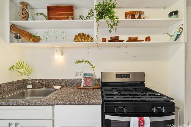 kitchen with gas stove, sink, and white cabinets