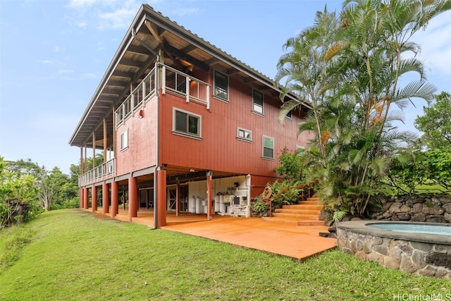 rear view of house featuring a patio area, a swimming pool, and a lawn