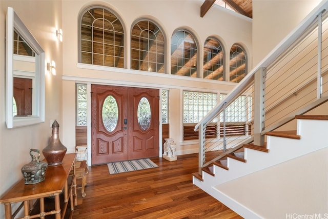 foyer featuring beam ceiling, high vaulted ceiling, and dark wood-type flooring