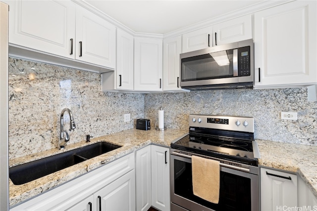 kitchen featuring appliances with stainless steel finishes, white cabinetry, and tasteful backsplash