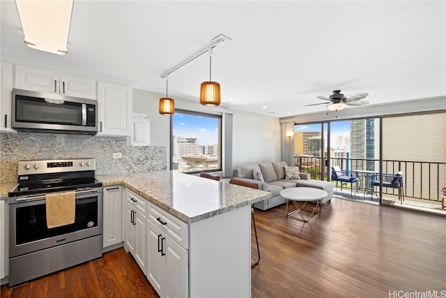 kitchen with white cabinetry, kitchen peninsula, stainless steel appliances, and a healthy amount of sunlight