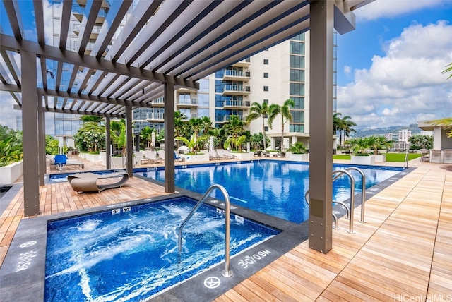 view of swimming pool featuring a hot tub, a patio, and a pergola