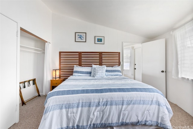 bedroom featuring lofted ceiling, a closet, and carpet