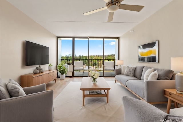 living room featuring light hardwood / wood-style floors, a wall of windows, and ceiling fan