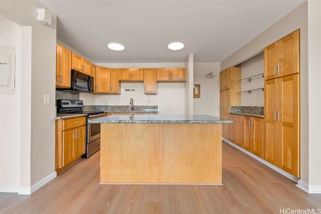 kitchen featuring sink, electric range, light wood-type flooring, and a kitchen island