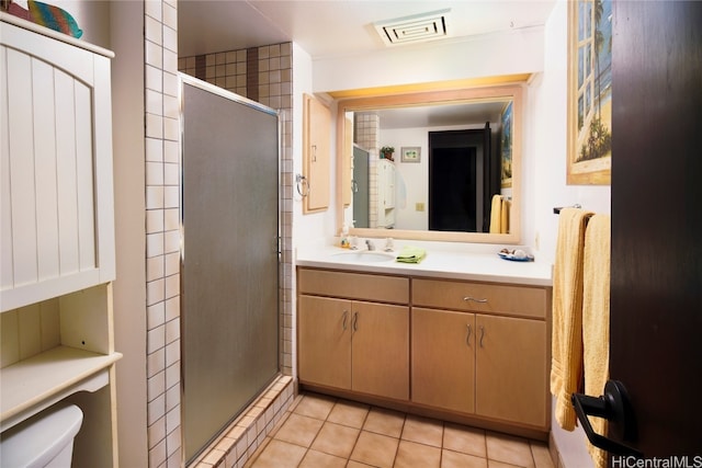 bathroom featuring vanity, an enclosed shower, toilet, and tile patterned floors