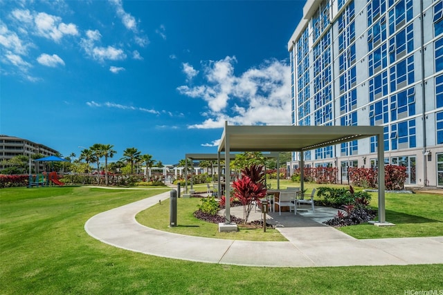 view of property's community with a yard and playground community