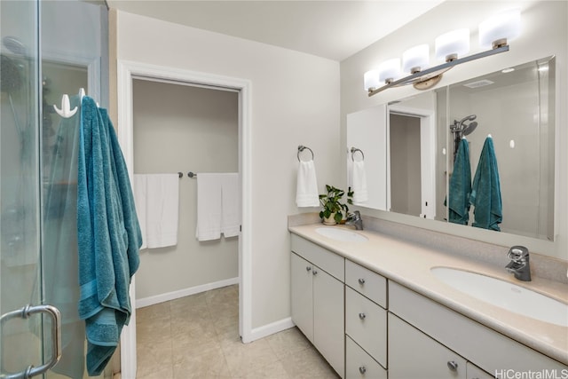 bathroom featuring tile patterned floors, vanity, and a shower with shower door